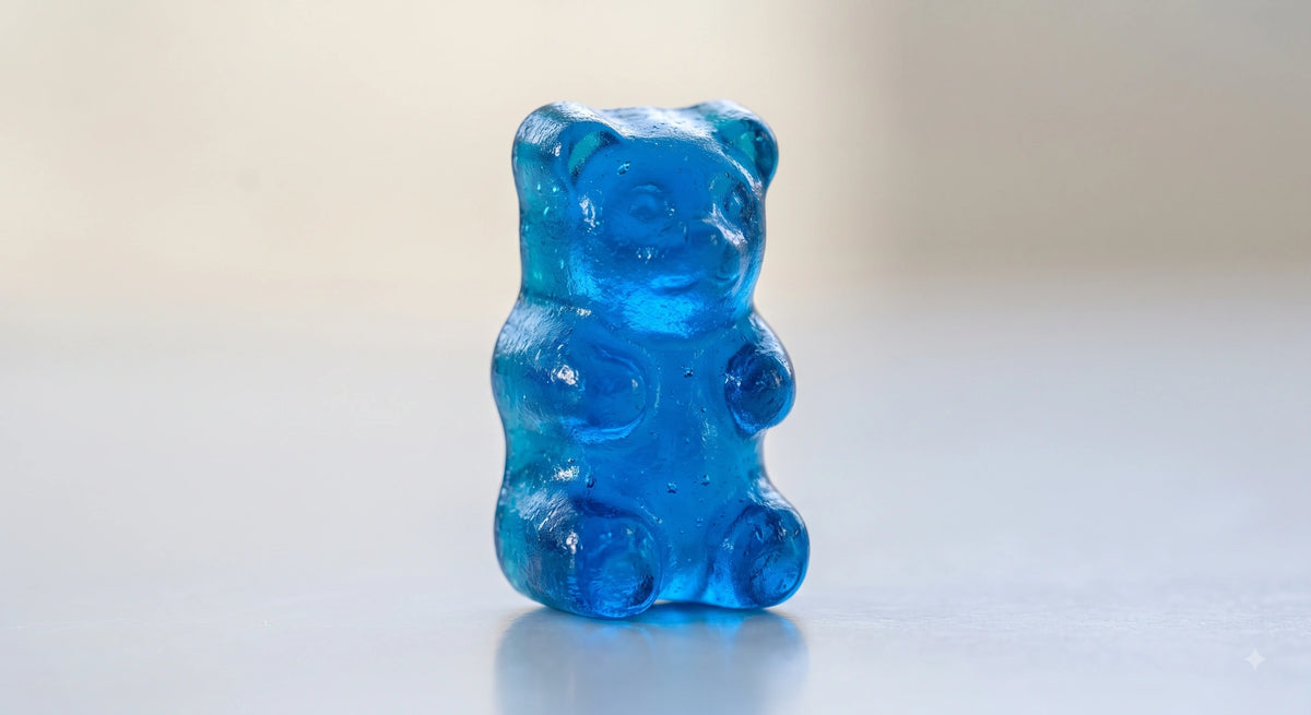 Colorful gummy bears in various shades, including red, blue, green, and orange, featuring a glossy, chewy texture.